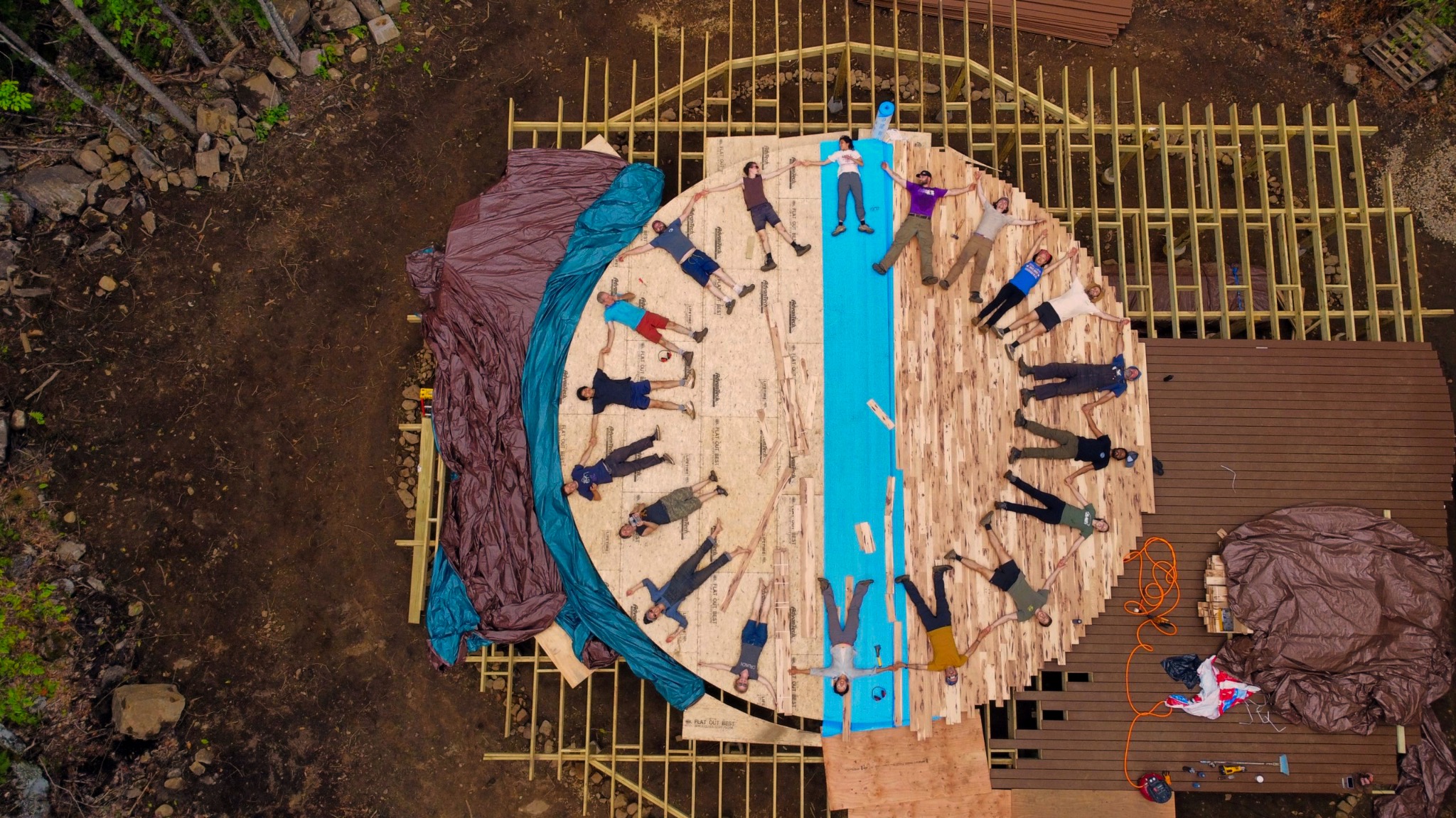 Friends lying on the unfinished yurt floor during a Dugnads gathering